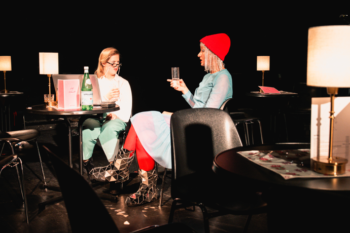 Fotocredit: Helena Käfer als Expertin Jay im Gespräch mit Foxy Fox (Sarah Sophia Meyer) (Fotocredit Lex Karelly) „Leck mich am Arsch, amore mio!“ vom Schauspielhaus Graz in Kooperation mit der Theaterakademie LebensGroß