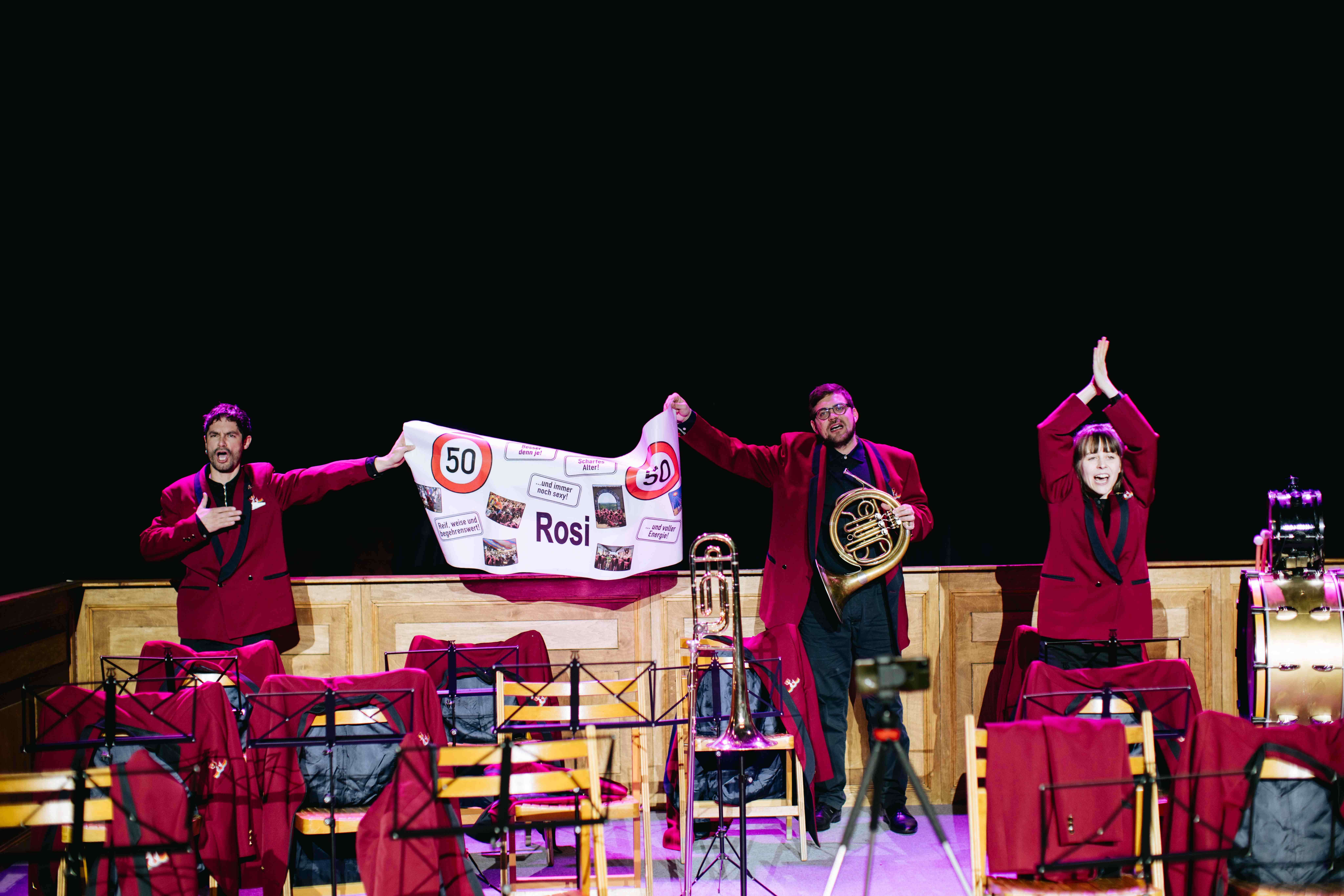 Fotocredit: Schriftführer (Max Gnant), Hornbläser (Christian Spitzenstätter) und Obfrau (Nora Winkler) beim Geburtstagsständchen (Fotocredit Igor Ripak) „Zur Rettung der Blasmusik“ von Bum Bum Pieces (AT) & vanderbolten.production (CH)