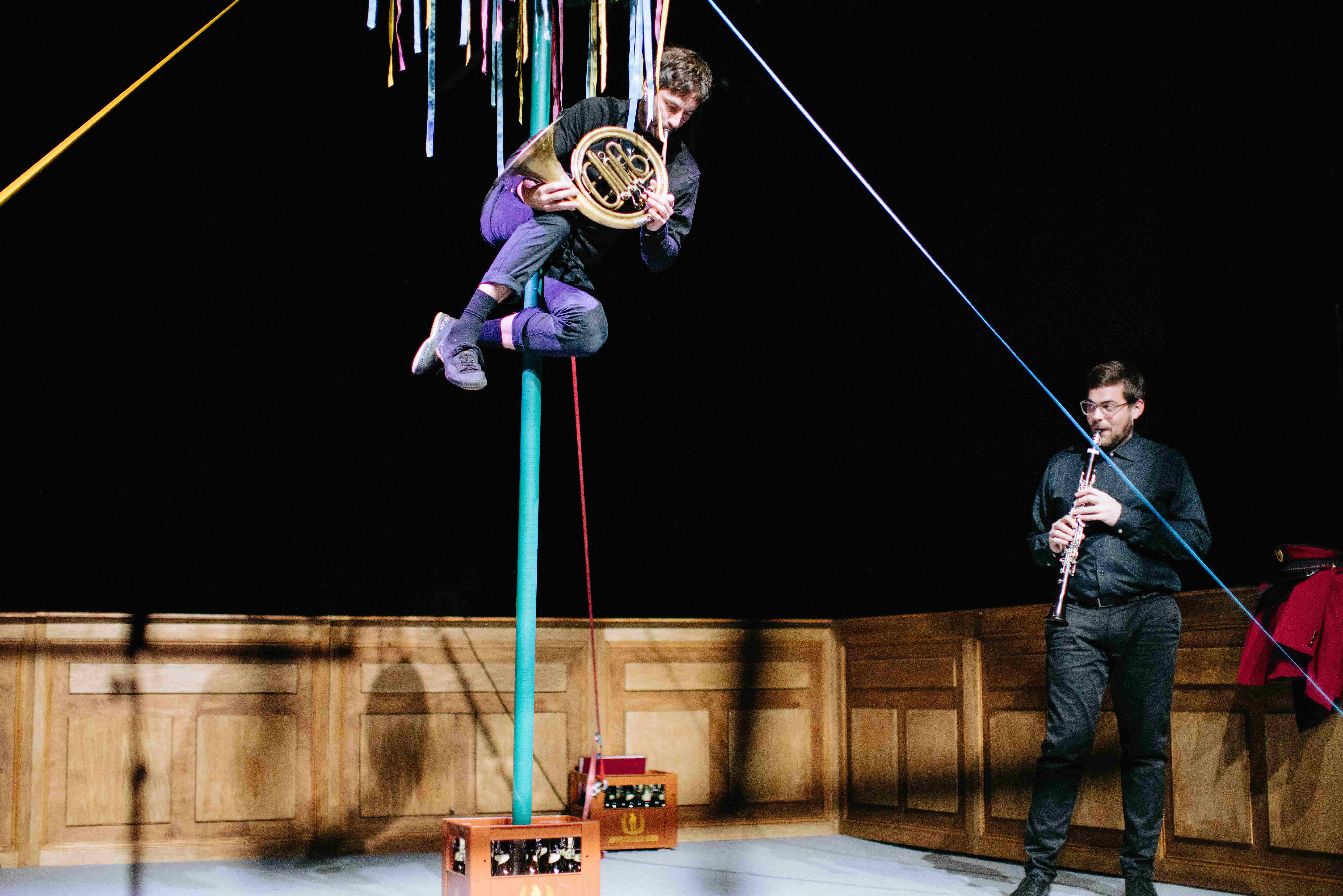 Fotocredit: Der Schriftführer als Hornbläser (Max Gnant) mit Klarinettist (Christian Spitzenstätter) musizierend am Maibaum (Fotocredit Igor Ripak) „Zur Rettung der Blasmusik“ von Bum Bum Pieces (AT) & vanderbolten.production (CH)