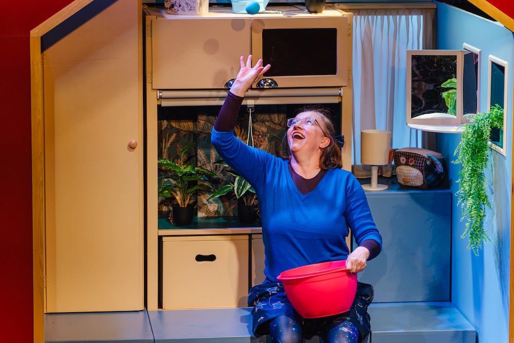 Fotocredit: Susanne Lipinski als Mara in einem zauberhaften Minihaus bei „Willkommen Daheim” von Mezzanin Theater. (Fotocredit: Edi Haberl) Kritik: Willkommen Daheim, Mezzanin Theater